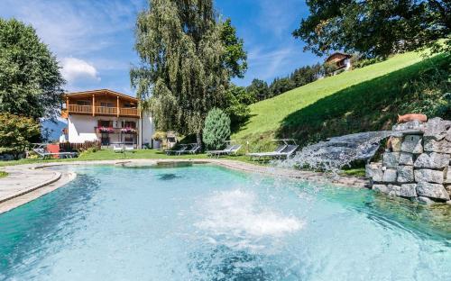 una piscina in un cortile con una casa di Hotel Fernblick a Bressanone