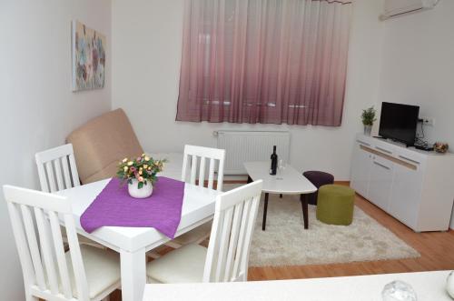 una piccola cucina e una sala da pranzo con tavolo e sedie di Apartment Kraljica a Banja Koviljača
