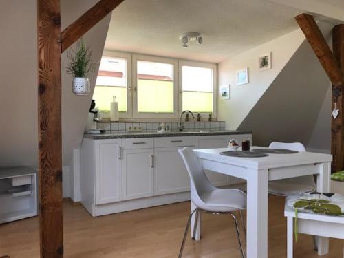 a kitchen with a sink and a table and chairs at Liebevoll eingerichtete Ferienwohnung im DG in Zwenkau