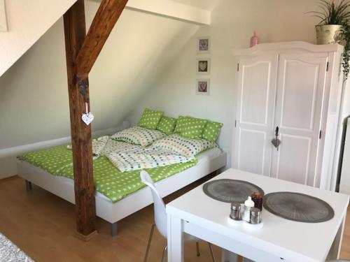 ツヴェンカウにあるLiebevoll eingerichtete Ferienwohnung im DGのベッド、テーブル、テーブル、椅子が備わる小さな客室です。