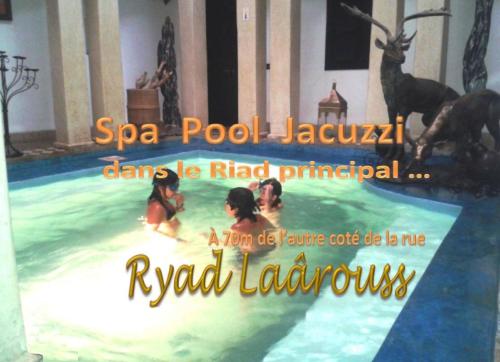 a poster of a group of people in a swimming pool at Ryad Laârouss Family in Marrakech