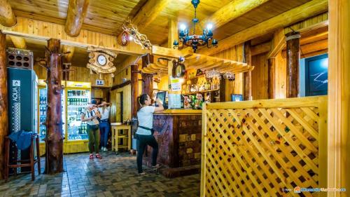 zwei Personen stehen in einer Bar in einem Restaurant in der Unterkunft Taverna Ceahlau in Durau