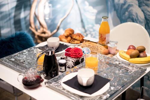 una mesa con una bandeja de alimentos para el desayuno y zumo de naranja en La Bergerie du Miravidi en Bourg-Saint-Maurice