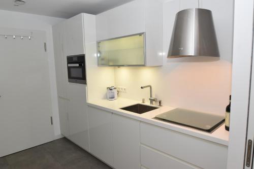 a kitchen with white cabinets and a sink at Loft 5 - Urlaub direkt an der Förde in Flensburg