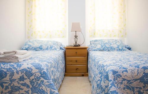 sypialnia z 2 łóżkami, komodą i oknami w obiekcie Apartamentos Turísticos Fercomar w mieście Nerja