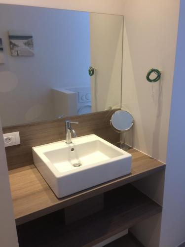 ein Badezimmer mit einem weißen Waschbecken und einem Spiegel in der Unterkunft ChilloutOostende in Ostende