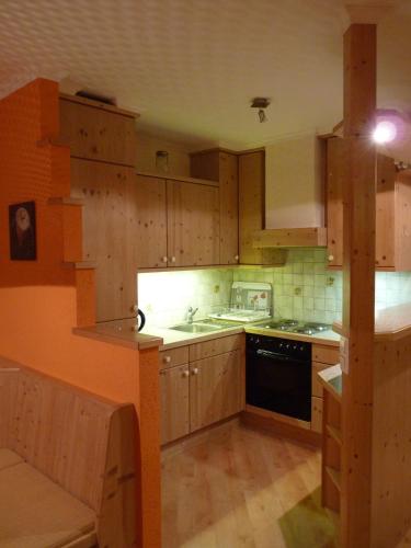 a kitchen with wooden cabinets and a stove top oven at Conny's Ferienwohnungen in Gschnitz