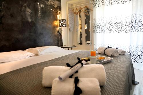 ナポリにあるHouse Tribunaliのベッドルーム1室(タオル、食料品のトレイ付)