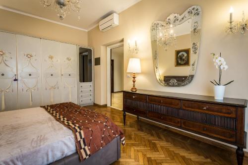 Schlafzimmer mit einem Bett, einer Kommode und einem Spiegel in der Unterkunft FerrHouse Charm in Florence Two lifts in Florenz