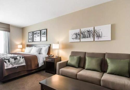 ハンニバルにあるSleep Inn & Suites Hannibalのベッドとソファ付きのホテルルーム