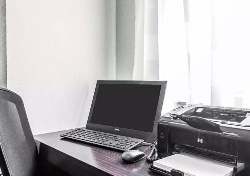 a desk with a laptop computer and a printer at Sleep Inn & Suites Hannibal West in Hannibal