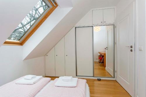 een slaapkamer op zolder met 2 bedden en een raam bij Horizon Forest moj-sopot pl in Sopot