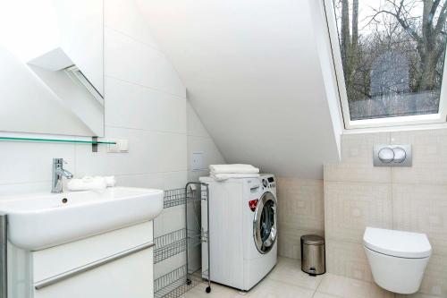 een badkamer met een wasmachine en een wastafel bij Horizon Forest moj-sopot pl in Sopot