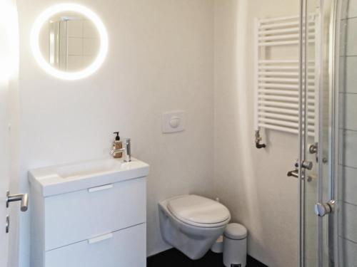a white bathroom with a toilet and a sink at Natura Apartments in Laugar