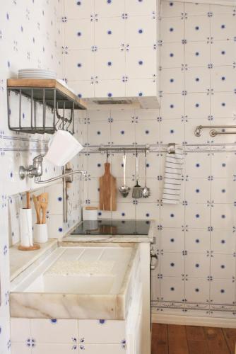 a kitchen with white and blue tiles at Casa do Mercado in Aveiro