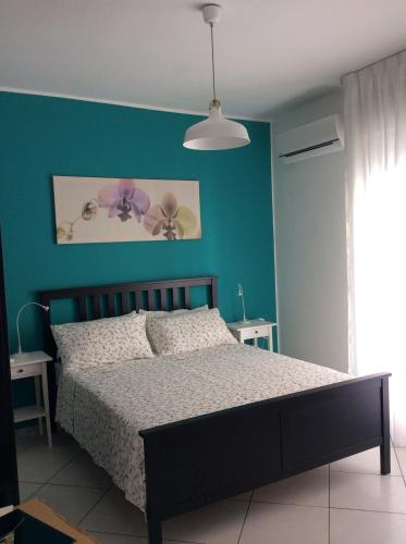 1 dormitorio con cama y pared azul en Al Borgo, en Gela
