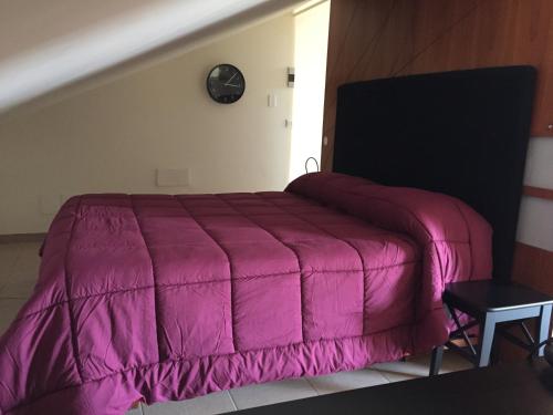 ジャッレにあるEtna loftのピンクの掛け布団付きのベッド1台
