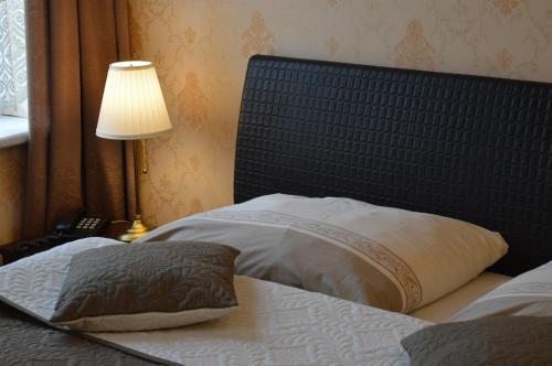a bedroom with a bed with a headboard and a lamp at Hotel Lipa in Bojnice