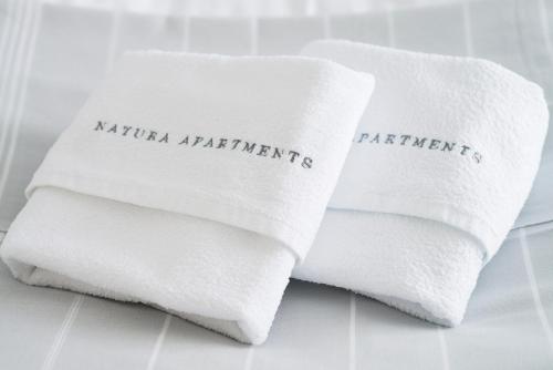 two white towels with the words natural supplements on them at Natura Apartments in Laugar