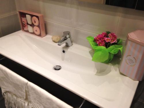 a bathroom sink with a vase of flowers on it at Casa Chicca Free Parking in Genova