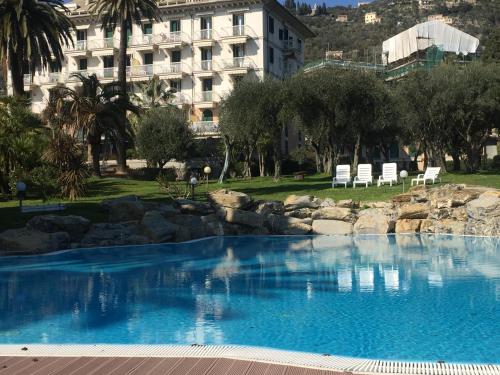 a large blue swimming pool with a building in the background at Casa Chicca Free Parking in Genova