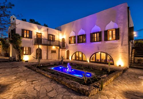 a house with a fountain in front of it at Lemuria Manor, Wine Dark Sea Villas in Rhodes Town