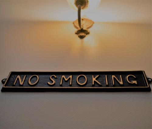 a sign that says no smoking hanging from a ceiling at Harlem Grand in New York