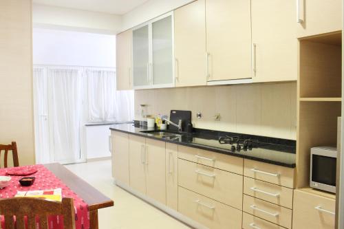 uma grande cozinha com armários brancos e uma mesa em Conforto em Fátima em Fátima