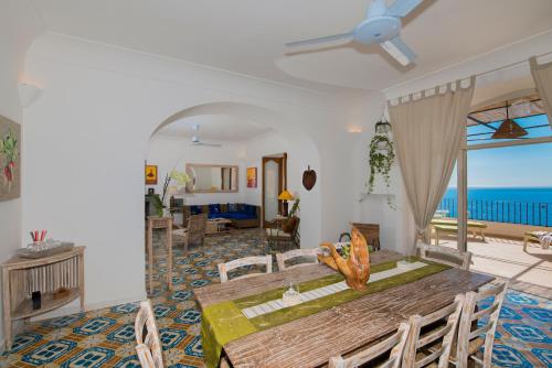 a dining room with a table and a living room at Casalbivio Positano in Positano
