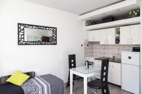 a kitchen and a living room with a table and chairs at Apartment Lapad Beach in Dubrovnik
