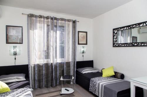 1 dormitorio con 2 camas y ventana en Apartment Lapad Beach, en Dubrovnik