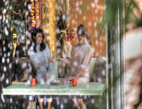 two girls sitting on a table talking to each other at Balinese onsen ryokan Hakone Airu in Hakone