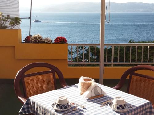una mesa y sillas con vistas al océano en Hotel Siroco, en Portonovo