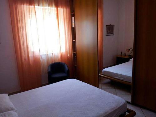 マラウサにあるVilletta al mareのベッドルーム1室(ベッド2台、椅子、窓付)