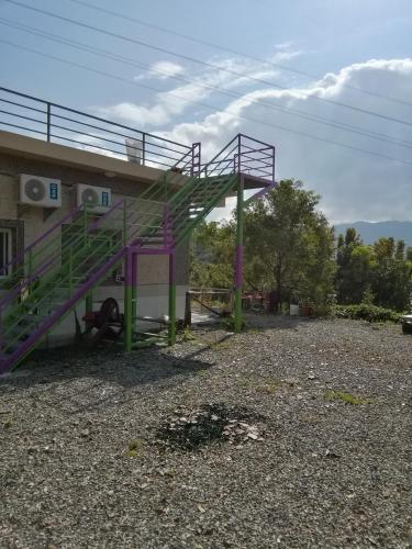 a purple metal staircase next to a building at 台東民宿 關山桃花心木民宿農場 in Guanshan