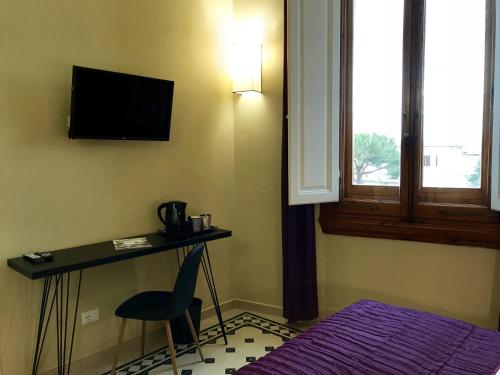 a room with a desk and a chair and a television at Guest House La Grancontessa in Florence