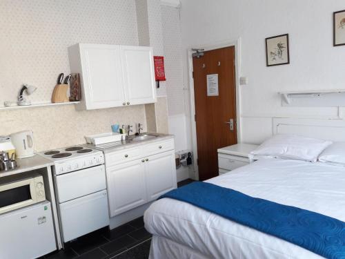 um pequeno quarto com uma cama e uma cozinha em Springfield Holiday Apartments em Skegness