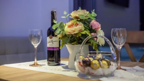 ein Tisch mit einer Flasche Wein und einer Vase mit Blumen in der Unterkunft Wicie Residence in Vitte