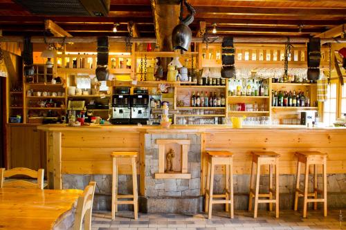 bar z drewnianymi stołkami w restauracji w obiekcie La Mollinière w mieście Notre-Dame-de-Bellecombe