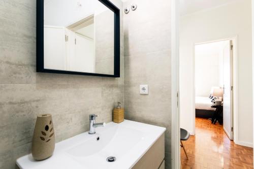 łazienka z umywalką i lustrem na ścianie w obiekcie WHome | Anjos Stylish Apartment #6 w Lizbonie