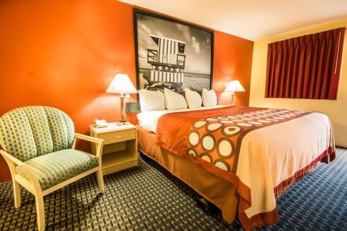 a hotel room with a large bed and a chair at Super 8 by Wyndham Chipley in Chipley