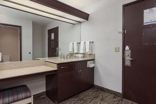 a bathroom with a sink and a large mirror at Shilo Inn Suites - Idaho Falls in Idaho Falls