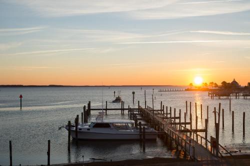 a boat docked at a dock at sunset at Wylder Hotel - Tilghman Island in Saint Michaels