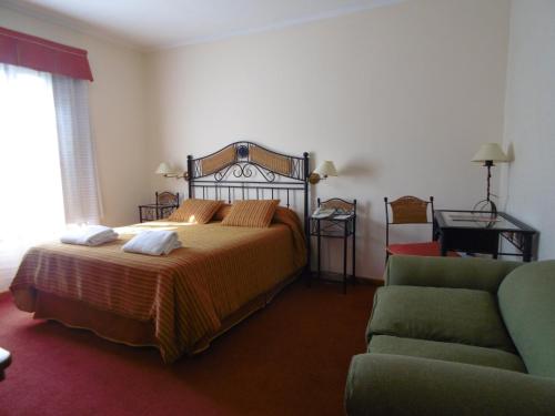 1 dormitorio con 1 cama y 1 sofá en Hostería Cumbres Blancas en Esquel