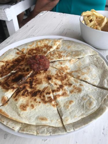 a pizza sitting on a plate on a table at Drifters@One Mile in Negril