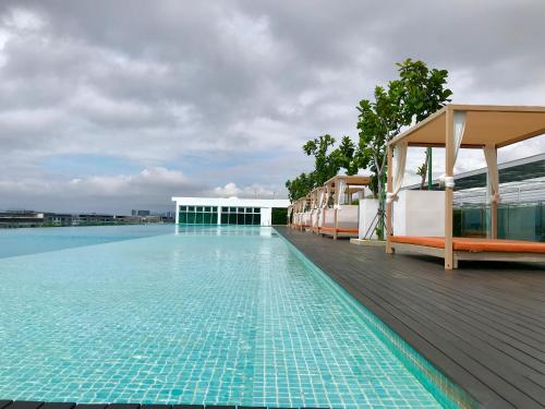 a swimming pool with blue water and a building at Sunset Seaview Vacation Condos @ Infinity Avenue in Kota Kinabalu