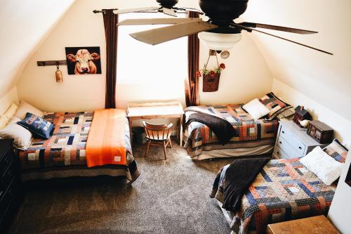 a attic room with two beds and a ceiling fan at Country Barn B and B in Stirling