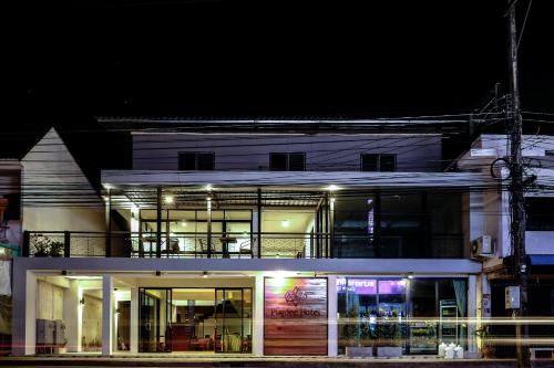 a large white building with glass windows at night at Pugdee Hotel in Lang Suan