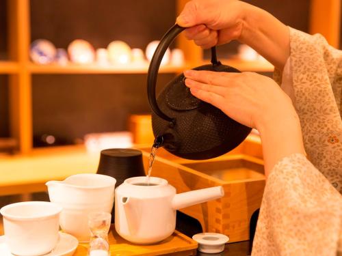 a woman is pouring coffee into a cup at UAN kanazawa in Kanazawa