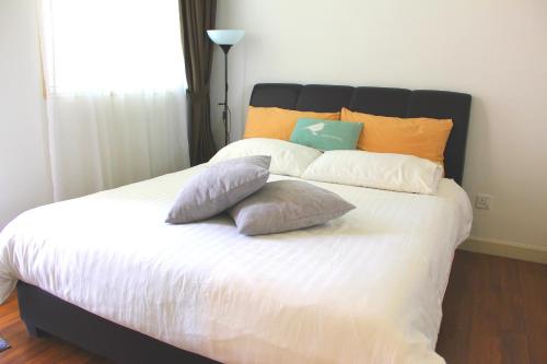 a bedroom with a bed with pillows on it at Afiniti Residensi Legoland Medini in Nusajaya